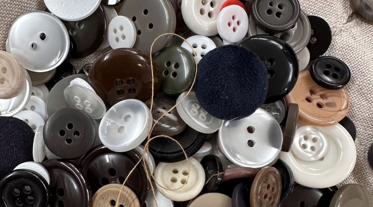 a mix of buttons in all different colours and sizes with a single thread