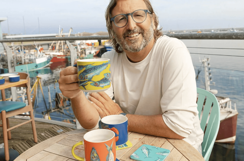 Mitch Tonks sat on quayside with a collection of Pure Table Top ceramic mugs.