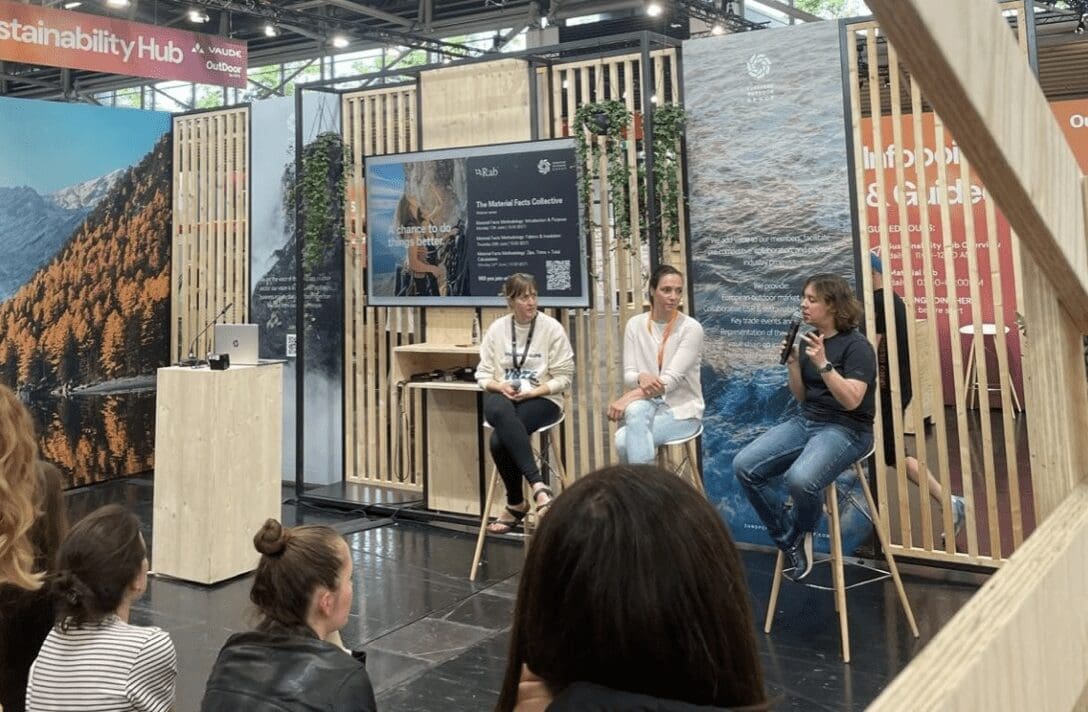 three women sit on a panel in front of an audience at a sustainability conference