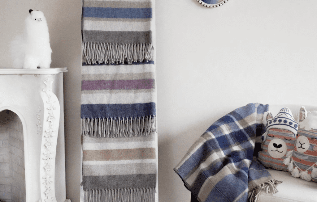 A bedroom setting featuring Peruvian made merino woollen items