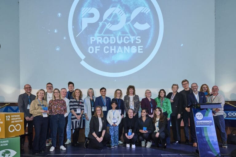 A group of people standing on a stage with the POC logo in the background