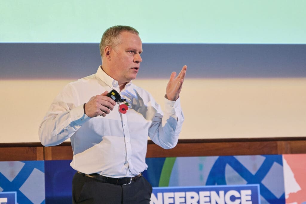 Mike Swain, POC Advisor, on stage at POCC 24.