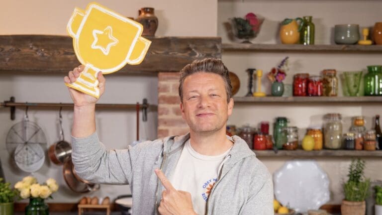 Jamie Oliver holding and posing with a trophy
