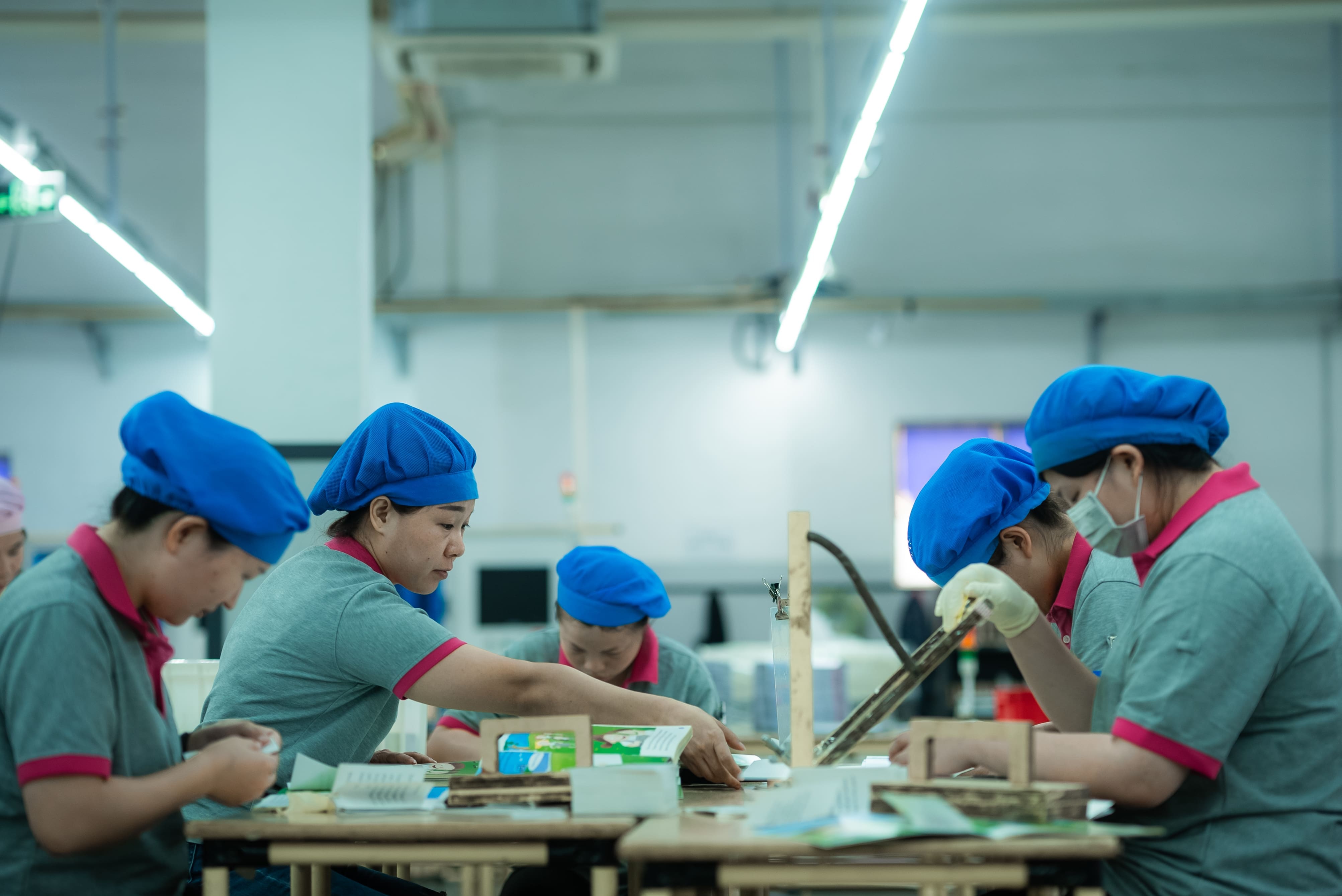 Workers at a table in a printing factory