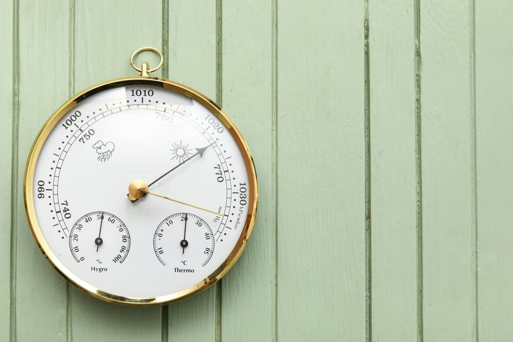 A barometer on a light green panel background