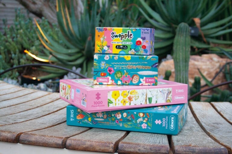 A stack of games and puzzles on a garden bench